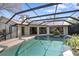 Sunlit screened-in pool with lush landscaping and seamless indoor-outdoor transition at 3416 Fairfield Trl, Clearwater, FL 33761