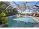 A sparkling pool enclosed in a screened-in lanai with lush tropical landscaping at 3416 Fairfield Trl, Clearwater, FL 33761