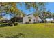 Beautiful backyard with a screened porch and lush green lawn under the shade of mature trees at 3807 Lake Joyce Dr, Land O Lakes, FL 34639