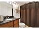 Bathroom featuring dark wood vanity, granite countertop and decorative mirror, exuding style and functionality at 4006 Crockers Lake Blvd # 212, Sarasota, FL 34238
