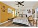Comfortable bedroom featuring a decorative rug, warm yellow accent wall, and ceiling fan at 4006 Crockers Lake Blvd # 212, Sarasota, FL 34238