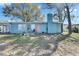 Rear exterior of home with mature trees, a small patio, and a fenced yard at 4111 Moog Rd, Holiday, FL 34691