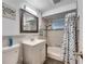 Updated bathroom with gray tiled walls, modern vanity, and shower/tub combo featuring a rainfall shower head at 4111 Moog Rd, Holiday, FL 34691