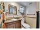 Bathroom with a dark wood vanity, tile backsplash, and a window at 4111 Moog Rd, Holiday, FL 34691