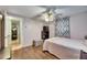 Cozy bedroom with laminate floors, TV, ceiling fan, and a view into the hallway and kitchen at 4111 Moog Rd, Holiday, FL 34691