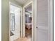 Hallway view leading to a bathroom with shower curtain and bedroom with wood flooring and ceiling fan at 4111 Moog Rd, Holiday, FL 34691