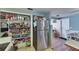 View of a well stocked pantry, stainless steel refrigerator, and adjacent dining area with blue accent wall at 4111 Moog Rd, Holiday, FL 34691
