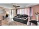 Comfortable living room with a leather sofa, wood floors, and a view of the front door at 4111 Moog Rd, Holiday, FL 34691