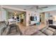 Open-concept living room with wood floors, a television, and seamless flow into the dining area at 4111 Moog Rd, Holiday, FL 34691