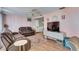 Cozy living room featuring comfortable couches, wood floors, and a television for entertainment at 4111 Moog Rd, Holiday, FL 34691