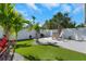 Backyard with palm trees, turf, and outdoor table and chairs at 423 62Nd St, Holmes Beach, FL 34217