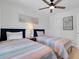 Bright bedroom featuring two twin beds, a ceiling fan, and tasteful coastal decor at 423 62Nd St, Holmes Beach, FL 34217