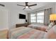 Inviting bedroom with twin beds, a ceiling fan, and natural light streaming through a large window at 423 62Nd St, Holmes Beach, FL 34217