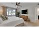 Well-lit bedroom with a ceiling fan, TV, and a large window overlooking the greenery at 423 62Nd St, Holmes Beach, FL 34217