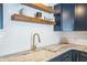 Close up on the sink, showcasing custom cabinets, stone countertop, and stainless steel appliances at 423 62Nd St, Holmes Beach, FL 34217