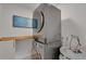 Convenient laundry area with a stacked washer and dryer, and a stylish wooden shelf for storage at 423 62Nd St, Holmes Beach, FL 34217