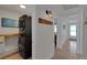 Practical laundry area with a stacked washer and dryer, adjacent to a hallway with stylish decor at 423 62Nd St, Holmes Beach, FL 34217