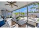 Bright sunroom with views of the fenced backyard, outdoor seating, and lush greenery at 423 62Nd St, Holmes Beach, FL 34217