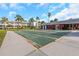 Shuffleboard court surrounded by lush landscaping and nearby buildings, creating a serene recreation area at 4742 Azalea Dr # 106, New Port Richey, FL 34652