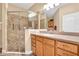 Bathroom with glass shower, tiled floors, and wooden cabinets at 4813 Michelle Ln, Palm Harbor, FL 34684