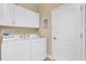 Bright laundry room features white washer and dryer along with overhead cabinets at 4813 Michelle Ln, Palm Harbor, FL 34684