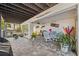 Covered back patio offers brick pavers, a ceiling fan, grill and an outdoor dining area at 5241 West Shore Dr, New Port Richey, FL 34652