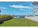 Spacious backyard with green grass, white fencing, and views of the waterfront at 5241 West Shore Dr, New Port Richey, FL 34652