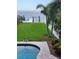 Inviting backyard featuring a pool, manicured lawn, and private dock leading to the serene waterfront at 5241 West Shore Dr, New Port Richey, FL 34652