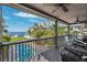 A covered deck overlooking a pool, lush greenery, and the ocean at 5241 West Shore Dr, New Port Richey, FL 34652