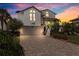 Charming two-story home featuring a brick paved driveway, lush landscaping, and inviting curb appeal at 5241 West Shore Dr, New Port Richey, FL 34652