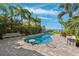 Private outdoor pool with lush tropical landscaping, a built-in table, and access to the beach and dock at 5241 West Shore Dr, New Port Richey, FL 34652