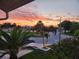 A scenic view of the neighborhood street at dusk featuring palm trees and landscaping at 5241 West Shore Dr, New Port Richey, FL 34652