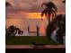 Beautiful sunset waterfront view with a private boat dock, lush palms, and serene landscape at 5241 West Shore Dr, New Port Richey, FL 34652