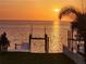 Stunning waterfront view at sunset featuring a private boat dock and picturesque scenery at 5241 West Shore Dr, New Port Richey, FL 34652