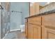 Bathroom featuring granite countertop, wooden cabinets and shower with neutral-toned curtain at 702 Lyndhurst St # 823, Dunedin, FL 34698