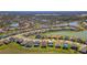 Aerial view of homes with manicured lawns and a serene lake, perfect for peaceful community living at 7096 Heron Walk Ln, Wesley Chapel, FL 33545