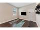 Bedroom area featuring dark flooring, window, TV and exercise equipment at 7096 Heron Walk Ln, Wesley Chapel, FL 33545