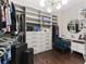 Walk-in closet with custom shelving, storage drawers, lighting, and a vanity area at 7096 Heron Walk Ln, Wesley Chapel, FL 33545