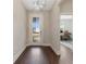 Bright foyer with wood flooring, modern light fixture, and view of the office at 7096 Heron Walk Ln, Wesley Chapel, FL 33545