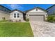 Charming single-story home with stone accents, a two-car garage, and manicured landscaping at 7096 Heron Walk Ln, Wesley Chapel, FL 33545