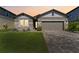 Charming single-story home with stone accents, a two-car garage, and manicured landscaping at 7096 Heron Walk Ln, Wesley Chapel, FL 33545