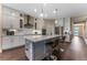 Modern kitchen featuring white cabinets, stainless steel appliances, and a large island with seating at 7096 Heron Walk Ln, Wesley Chapel, FL 33545