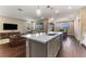 Open-concept kitchen with island, stainless steel appliances, and a view into the living room and dining area at 7096 Heron Walk Ln, Wesley Chapel, FL 33545