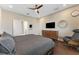 Spacious bedroom featuring a ceiling fan, dark wood floors, and contemporary furniture at 7096 Heron Walk Ln, Wesley Chapel, FL 33545