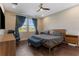 Relaxing main bedroom with a ceiling fan, two windows with blue curtains, and wood-look flooring at 7096 Heron Walk Ln, Wesley Chapel, FL 33545
