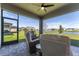 Patio featuring screened in porch and lake view at 7096 Heron Walk Ln, Wesley Chapel, FL 33545