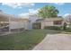 Exterior view of home with carport, green lawn and mature landscaping at 8001 Jasmine Dr # 8001, Temple Terrace, FL 33637