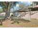 Exterior view of a townhouse with muted tones and a fenced patio under the shade of a large tree at 8001 Jasmine Dr # 8001, Temple Terrace, FL 33637