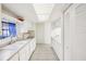 A well-lit kitchen with white cabinets, countertops, and appliances, featuring a tiled floor and a window over the sink at 8001 Jasmine Dr # 8001, Temple Terrace, FL 33637