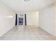 Bright and airy living room features neutral tile floors, white walls and a glass sliding door with dark blue curtains at 8001 Jasmine Dr # 8001, Temple Terrace, FL 33637